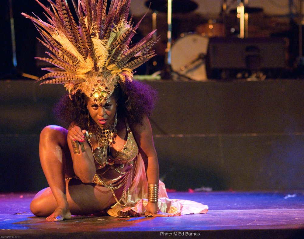 Akynos on stage in gold feather headdress